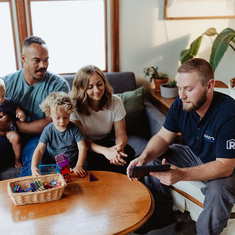 Family gathered around a table with a professional from Summmit discussing home inspection.