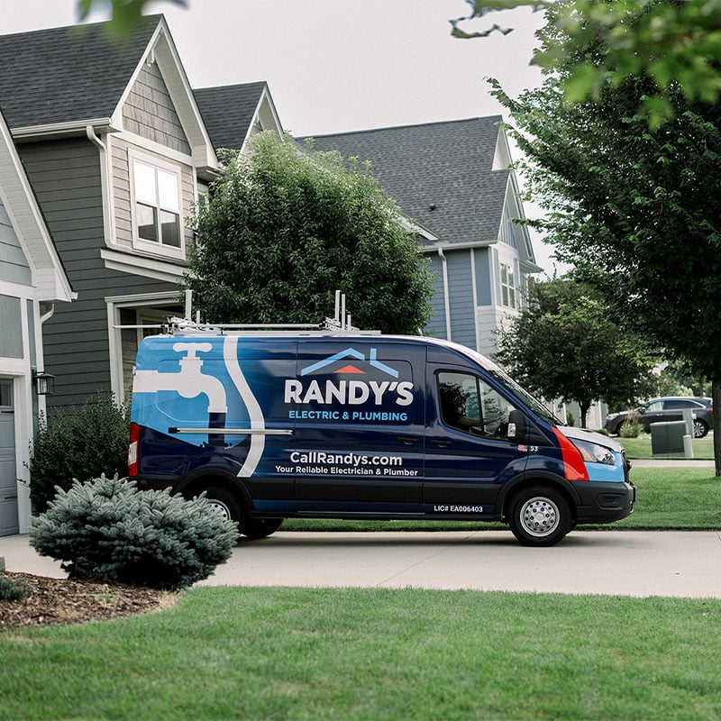 Summit Electric & Plumbing van parked in front of residential homes, showcasing their services.