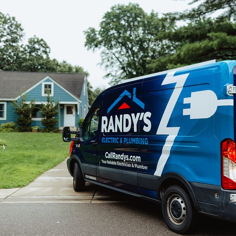 Summit Electric & Plumbing service van parked next to a blue house.