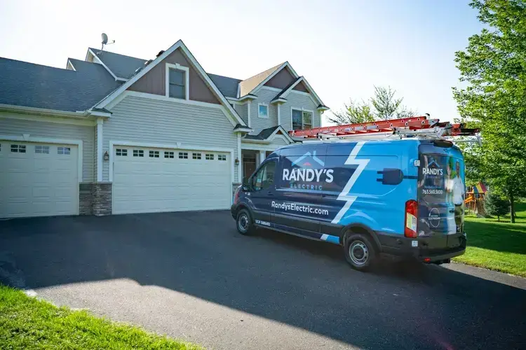 Electrician's van parked in a residential driveway with tools and branding from Summmit Electric.
