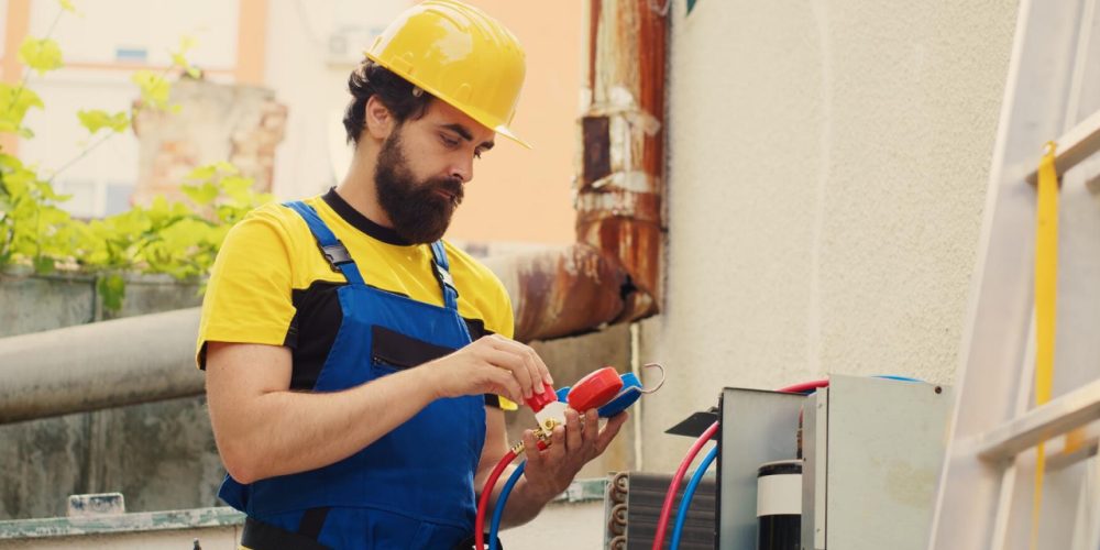 Electrician working on outdoor wiring with safety gear.