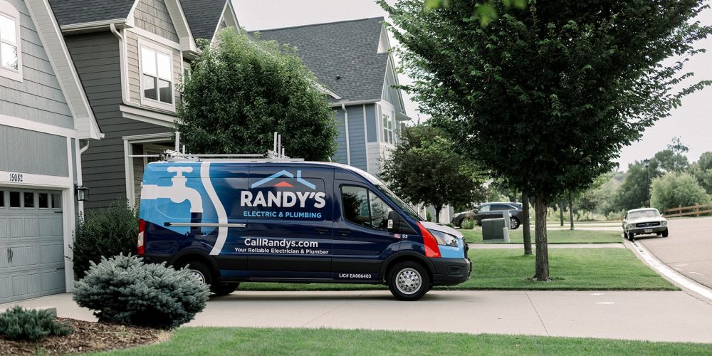 A Summit Electrical & Plumbing van parked outside of a suburban home.