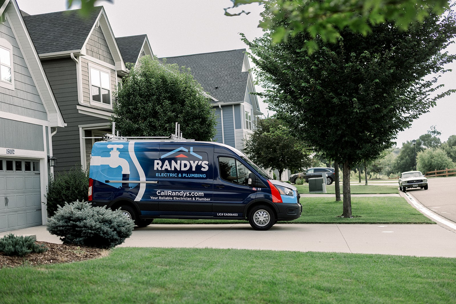 A Summit Electrical & Plumbing van parked outside of a suburban home.